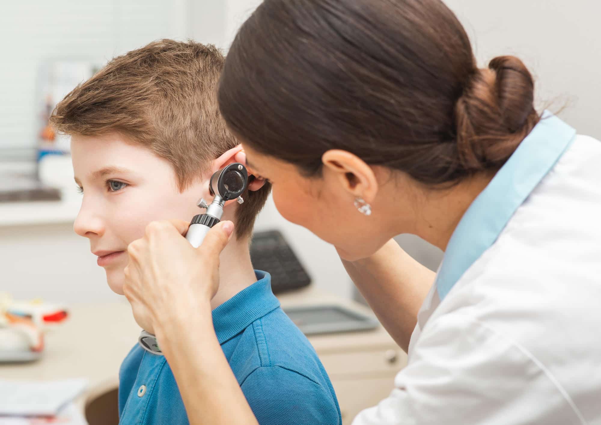 Audiologist with Otoscopy examining childs ear