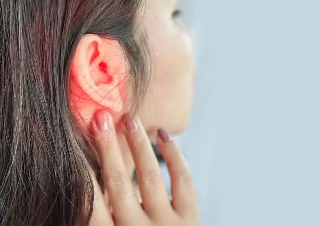 ringing buzzing tinnitus lady touches ear
