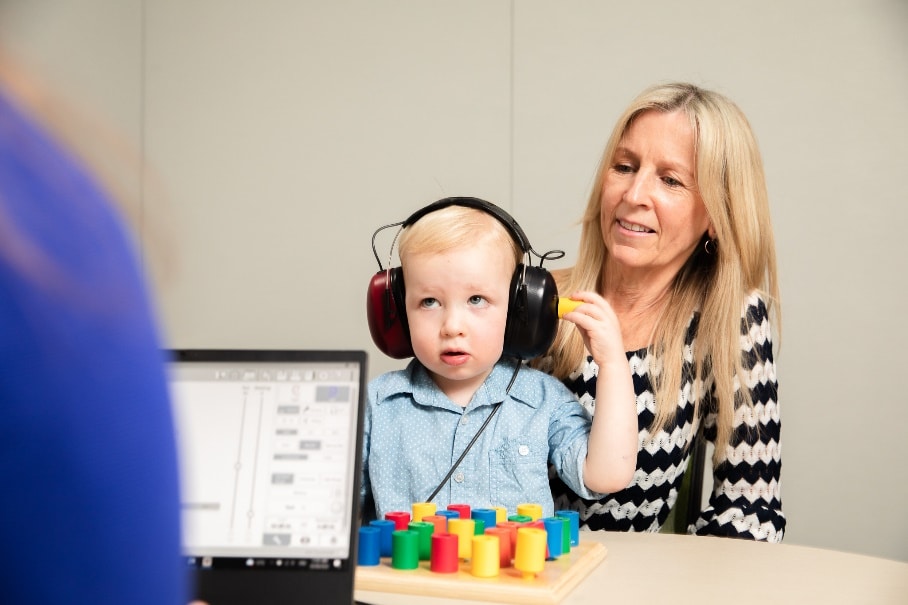Audiologist with child and its Mum