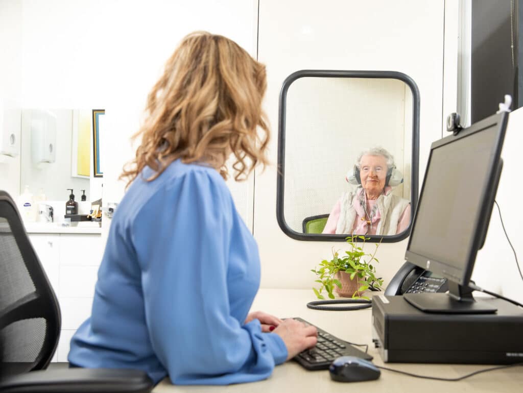 Audiologist with patient who is getting hearing test